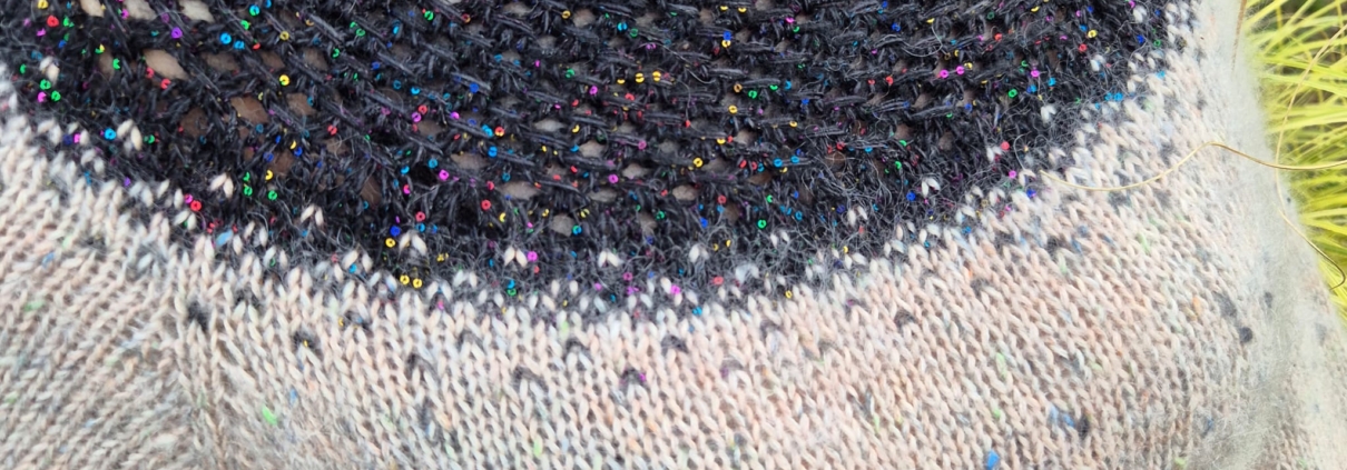 Pull tricoté Miraggio porté, avec un empiècement bleu foncé et des nuances claires sur le corps, réalisé en laine aux couleurs nuancées.