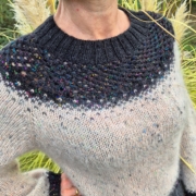 Pull tricoté Miraggio porté, avec un empiècement bleu foncé et des nuances claires sur le corps, réalisé en laine aux couleurs nuancées.